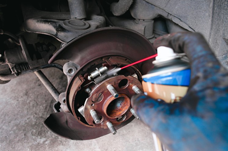 A person spraying paint on a brake disc